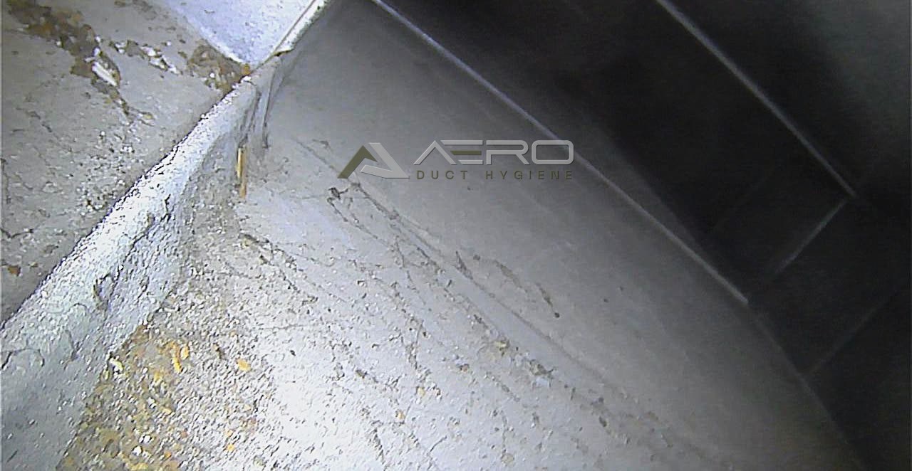 Debris accumulated along the base of a main supply duct