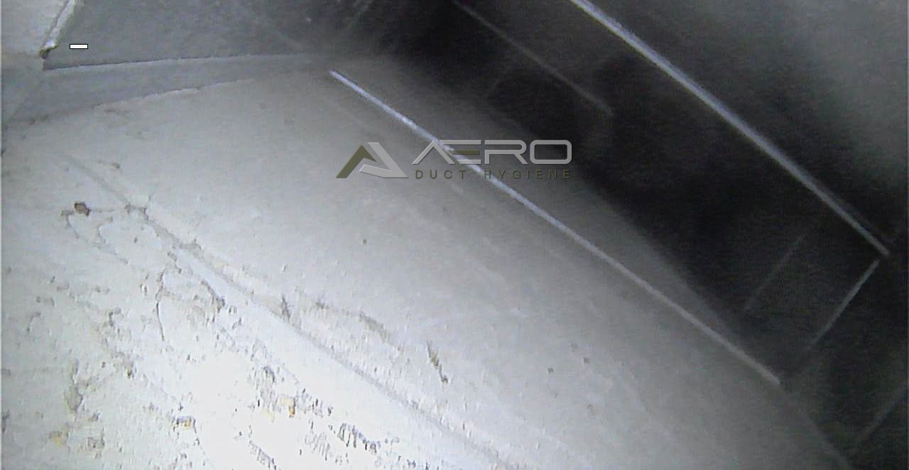 Inside a main supply duct, showing dust across the board surface