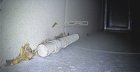 Dust and debris packed around a pipe passing through the ductwork