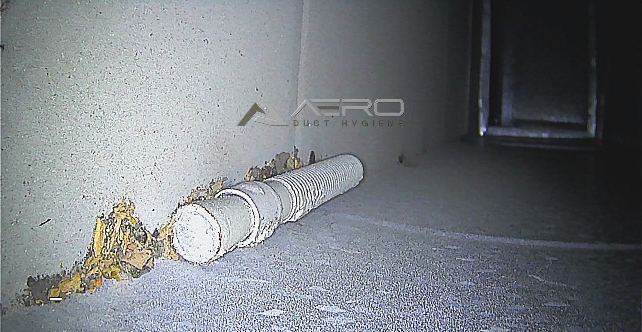 Dust and debris packed around a pipe passing through the ductwork